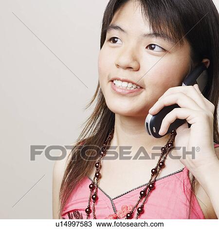 Stock Image - Close-up of a young woman talking on a mobile phone. Fotosearch