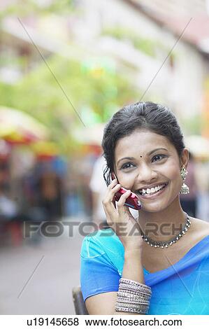 Stock Photo - Close-up of a young woman talking on a mobile phone. Fotosearch