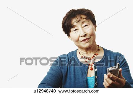 Stock Image - Portrait of a mature woman holding a mobile phone. Fotosearch
