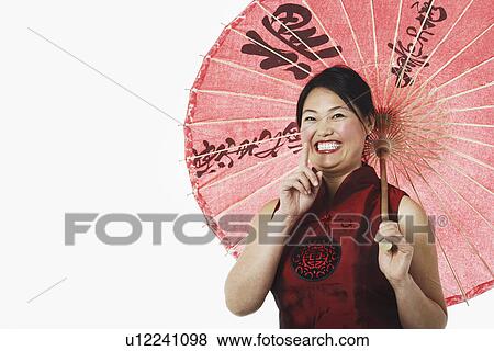 Stock Photo - Portrait of a mid adult woman holding a parasol. Fotosearch