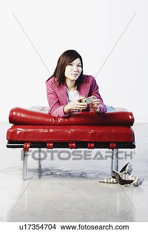 Portrait of a young woman holding a digital camera View Large Photo Image Picture - Portrait of a young woman holding a digital camera. Fotosearch
