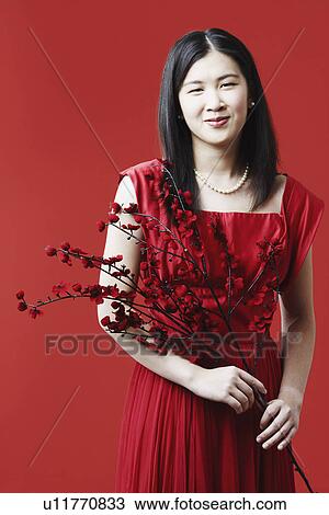 Stock Image - Portrait of a young woman holding flowers. Fotosearch