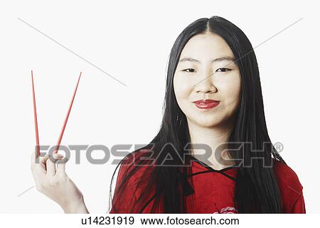 Portrait of a young woman holding chopsticks View Large Photo Image Stock Photo - Portrait of a young woman holding chopsticks. Fotosearch