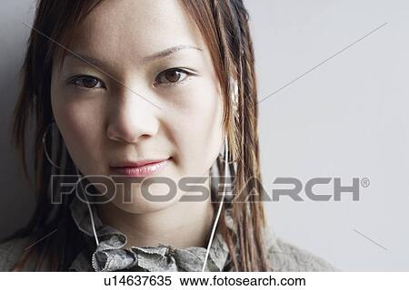 Stock Photography - Portrait of a young woman listening to music. Fotosearch
