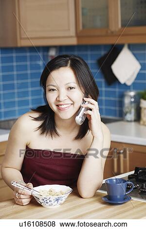 Stock Photo - Portrait of a young woman talking on a mobile phone smiling. Fotosearch