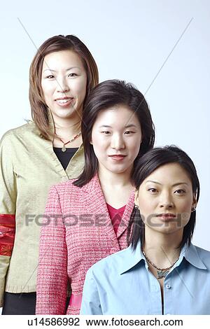 Stock Image - Portrait of three businesswomen standing in a row. Fotosearch