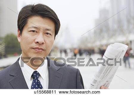 Portrait of a businessman holding a newspaper View Large Photo Image Stock Image - Portrait of a businessman holding a newspaper. Fotosearch
