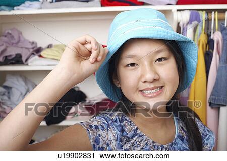 Stock Image - Portrait of a girl holding a hat. Fotosearch