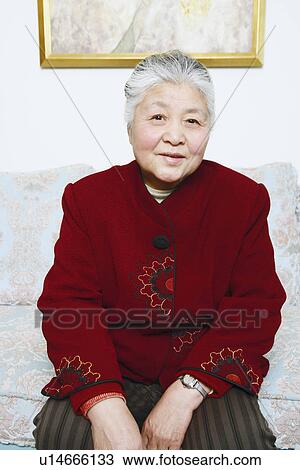 Stock Image - Portrait of a senior woman sitting on a couch. Fotosearch