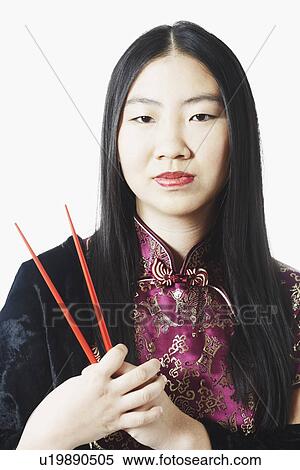 Portrait of a young woman holding chopsticks View Large Photo Image Stock Photography - Portrait of a young woman holding chopsticks. Fotosearch