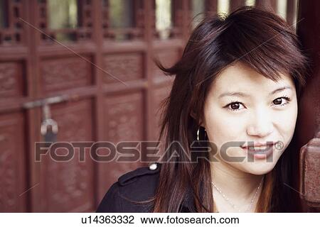Portrait of a young woman leaning against a column smiling View Large Photo Image Stock Image - Portrait of a young woman leaning against a column smiling. Fotosearch