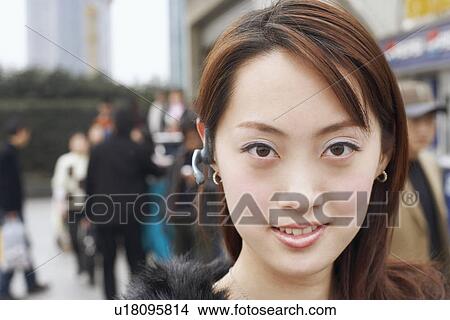 Portrait of a young woman wearing a hands free device View Large Photo Image Picture - Portrait of a young woman wearing a hands free device. Fotosearch