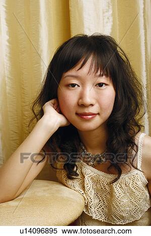 Portrait of a young woman with her hands on her head View Large Photo Image Stock Photography - Portrait of a young woman with her hands on her head. Fotosearch