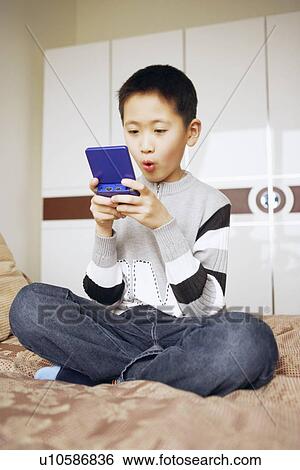 Stock Photograph - Boy playing a video game. Fotosearch
