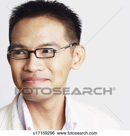 Stock Photograph - Close-up of a businessman looking away and smirking. Fotosearch