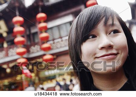 Close-up of a young woman looking away View Large Photo Image Stock Photo - Close-up of a young woman looking away. Fotosearch