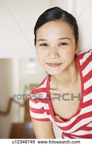 Stock Photo - Portrait of a young woman smirking. Fotosearch