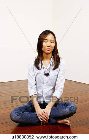 Stock Image - Young woman thinking with her eyes closed. Fotosearch
