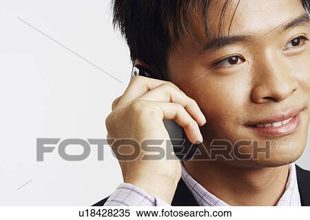 Stock Photography - Close-up of a businessman talking on a mobile phone. Fotosearch