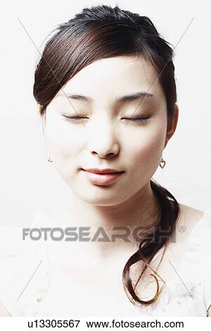 Close-up of a young woman with her eyes closed View Large Photo Image Stock Photo - Close-up of a young woman with her eyes closed. Fotosearch