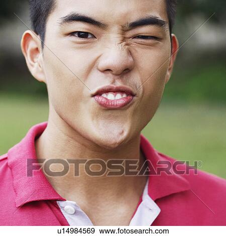 Portrait of a young man making a face View Large Photo Image Stock Photo - Portrait of a young man making a face. Fotosearch