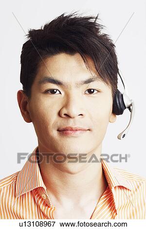 Stock Photo - Portrait of a young man wearing a headset. Fotosearch