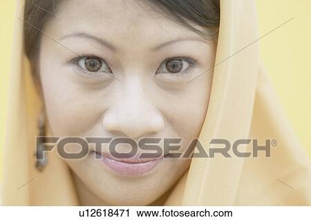Stock Image - Portrait of a young woman wearing a scarf. Fotosearch