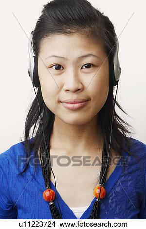 Picture - Portrait of a young woman wearing headphones and listening to music. Fotosearch