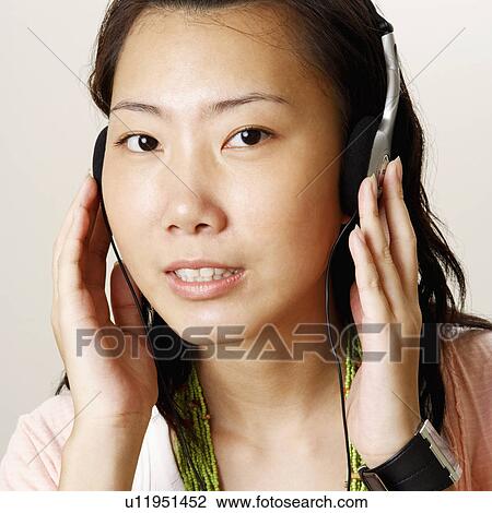 Portrait of a young woman wearing headphones and smiling View Large Photo Image Stock Image - Portrait of a young woman wearing headphones and smiling. Fotosearch