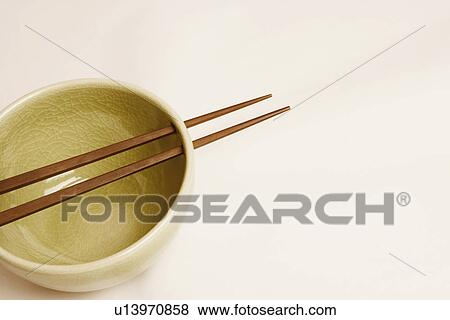 Stock Photo - High angle view of a bowl and two chopsticks. Fotosearch