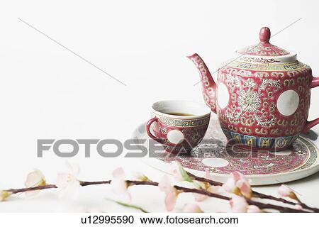Stock Image - High angle view of a cup of black tea and a teapot on a tray. Fotosearch