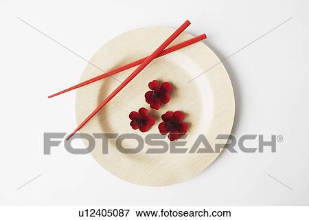 Stock Photo - High angle view of flowers and a pair of chopsticks on a plate. Fotosearch