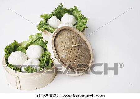 Stock Image - High angle view of steamed dumplings in a steamer. Fotosearch