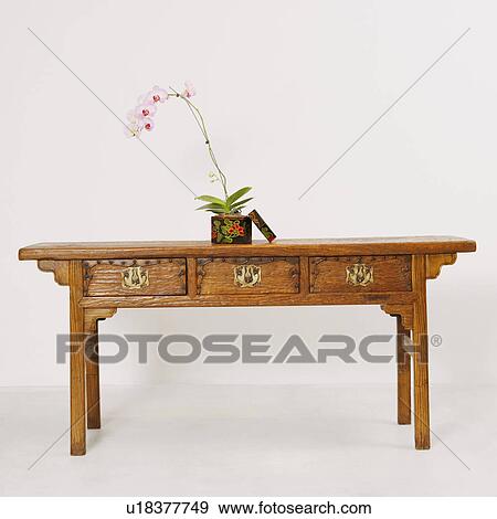 Potted plant in a container on a wooden desk View Large Photo Image Stock Photo - Potted plant in a container on a wooden desk. Fotosearch