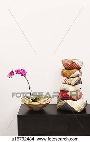 Stack of cushions and a potted plant on a cabinet View Large Photo Image Picture - Stack of cushions and a potted plant on a cabinet. Fotosearch