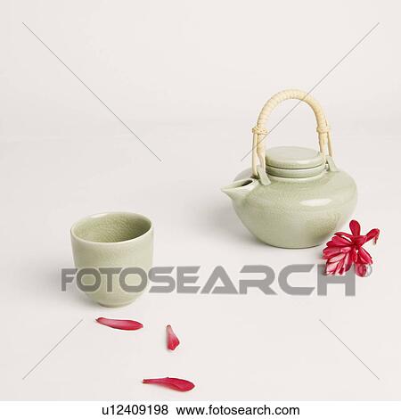 Stock Photo - Tea cup and a tea kettle with flower petals. Fotosearch