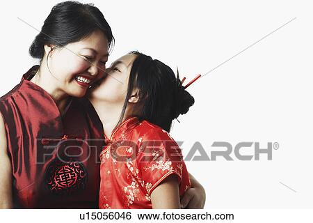 Stock Photograph - Close-up of a daughter kissing her mother. Fotosearch
