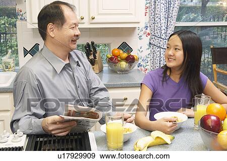 Stock Photo - Close-up of a father and his daughter in the kitchen. Fotosearch