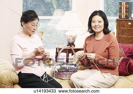 Stock Image - Close-up of a mother and her daughter knitting. Fotosearch