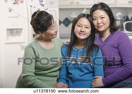 Stock Image - Portrait of a girl smiling with her mother and grandmother. Fotosearch