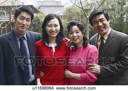 Portrait of a mature couple standing with a young couple View Large Photo Image Picture - Portrait of a mature couple standing with a young couple. Fotosearch