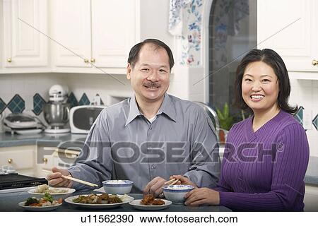Stock Image - Portrait of a senior man smiling with a mature woman at the breakfast table. Fotosearch