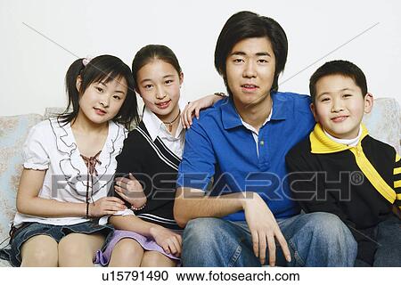 Stock Image - Portrait of brothers and sisters sitting together. Fotosearch