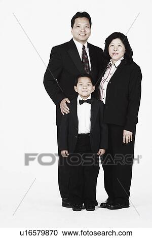 Stock Image - Portrait of parents standing together with their son smiling. Fotosearch
