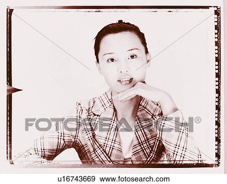 Close-up of a young woman with her hand on chin View Large Photo Image Stock Photo - Close-up of a young woman with her hand on chin. Fotosearch