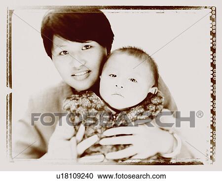 Stock Image - Portrait of a mother holding her daughter. Fotosearch