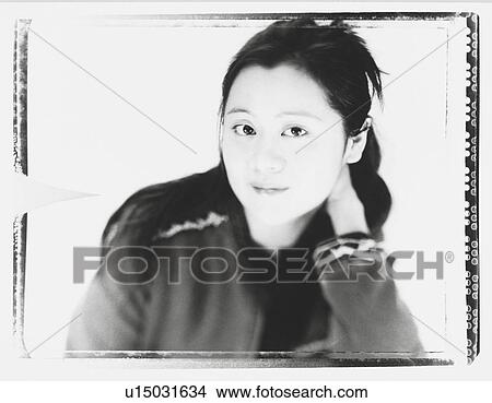 Picture - Portrait of a young woman with her hand in hair. Fotosearch