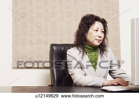 Businesswoman using a computer View Large Photo Image Stock Photo - Businesswoman using a computer. Fotosearch