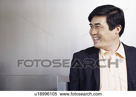 Close-up of a businessman looking sideways smiling View Large Photo Image Stock Photography - Close-up of a businessman looking sideways smiling. Fotosearch