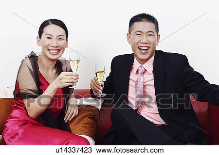 Portrait of a businessman and a mid adult woman holding glasses of champagne and laughing View Large Photo Image Stock Image - Portrait of a businessman and a mid adult woman holding glasses of champagne and laughing. Fotosearch